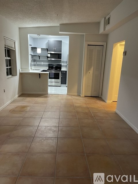 A kitchen area with tile flooring and a view into another room.