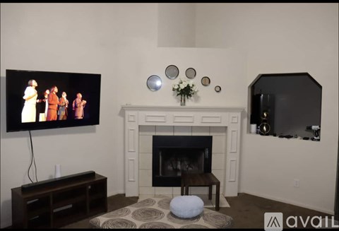 A living room with a fireplace and a television on the wall.
