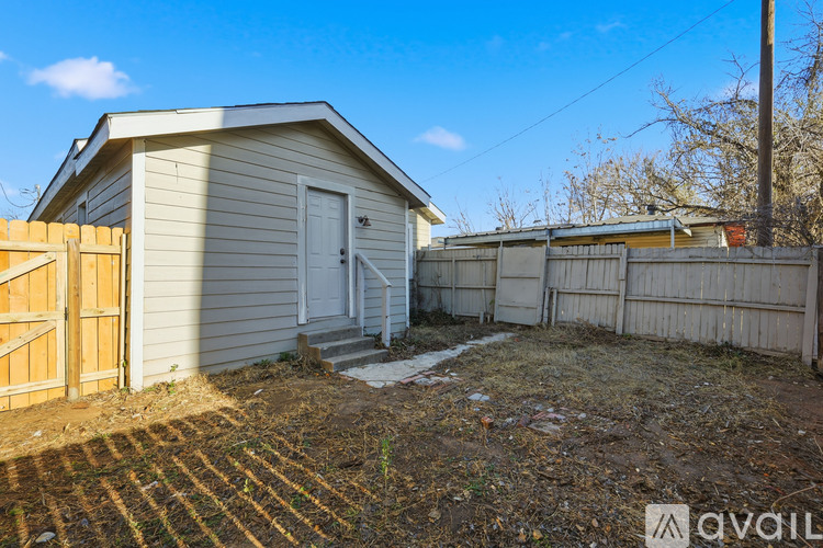 A small house with a wooden fence in front of it.
