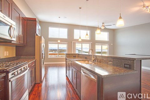 A kitchen with dark wood cabinets and stainless steel appliances.
