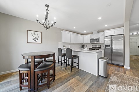A modern kitchen with a wooden table and chairs.