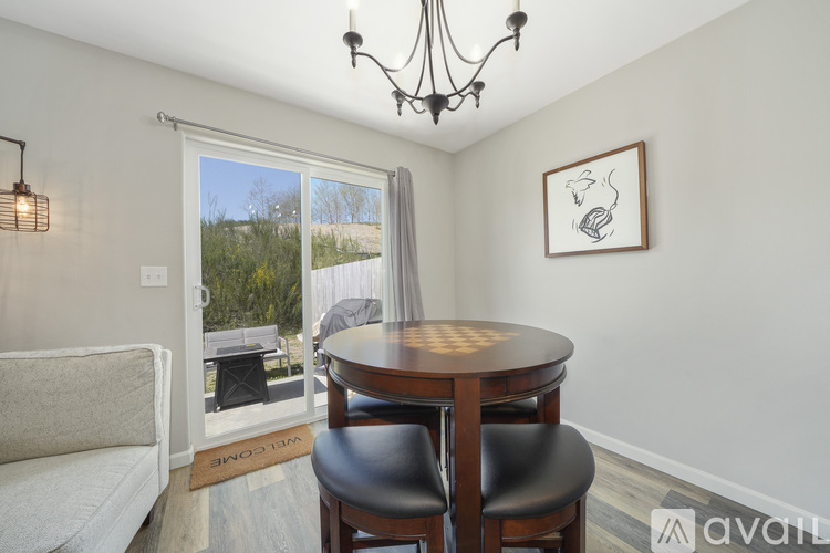 A dining room with a round table and two chairs.