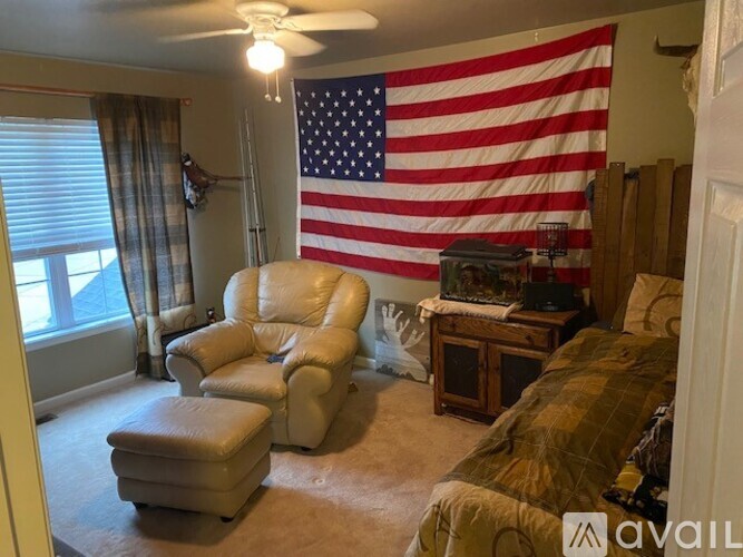 A living room with a large American flag hanging on the wall.