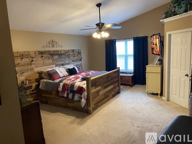 A bedroom with a bed, dresser, and window.