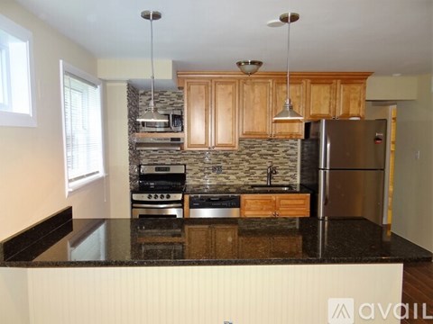 A kitchen with wooden cabinets and granite countertops.