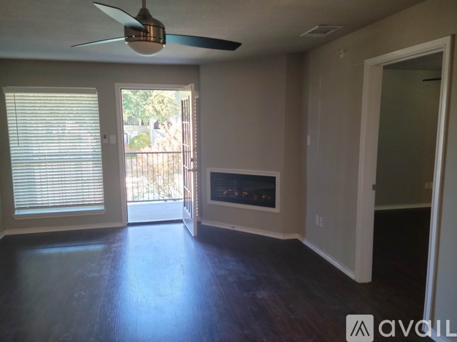 A room with a ceiling fan and sliding glass doors.