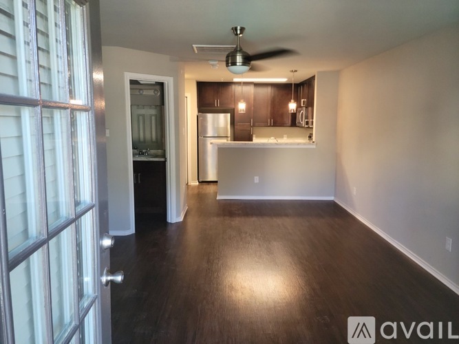 A spacious room with wooden floors and a ceiling fan.