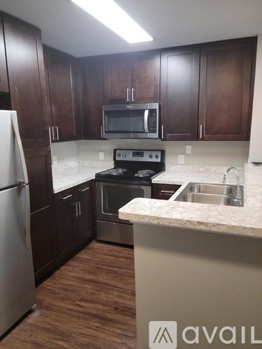 A kitchen with brown cabinets and a white fridge.