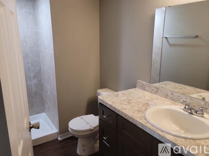 A bathroom with a toilet, sink, and mirror.