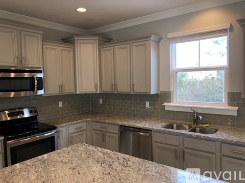 A kitchen with granite countertops and white cabinets.