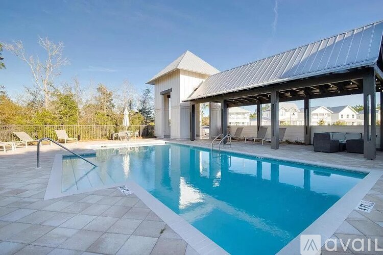 A pool with a small building behind it.