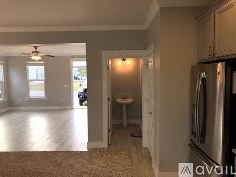 A kitchen with a refrigerator, table, and chairs is available for rent.