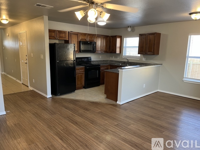 A kitchen with black appliances and wooden cabinets.