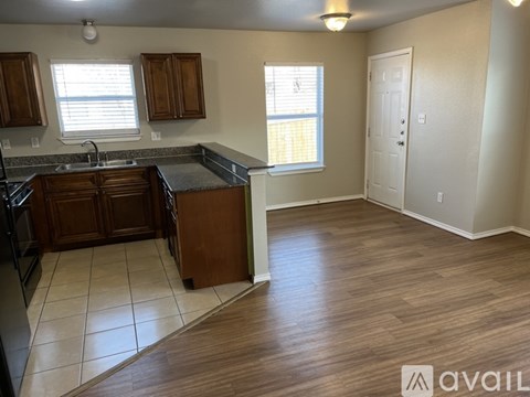 A kitchen with wooden cabinets and a black countertop.