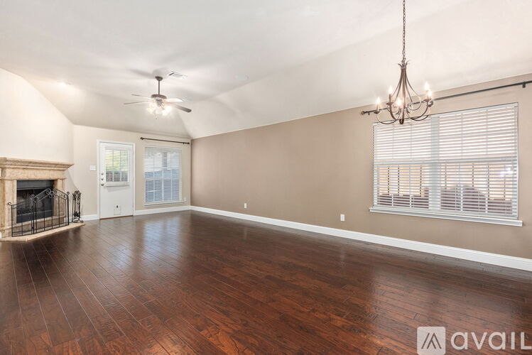 A spacious room with a fireplace and wood flooring.