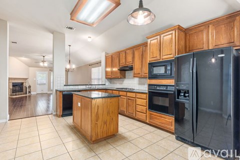 A kitchen with wooden cabinets and black appliances.