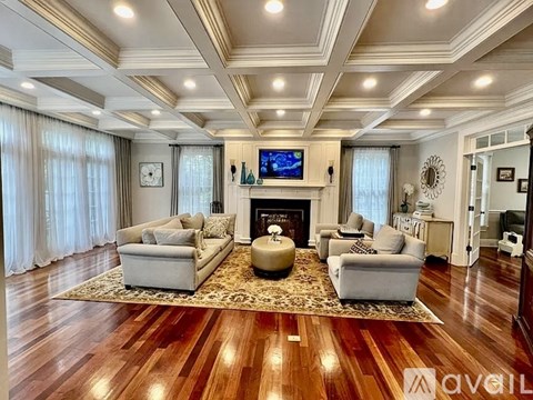 A living room with a fireplace and a television on the wall.