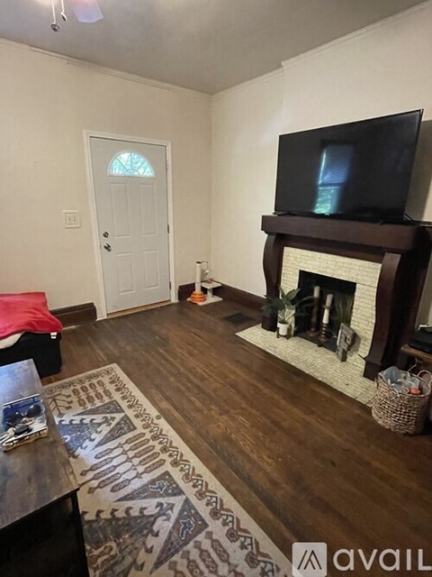 A living room with a fireplace and a television on the wall.