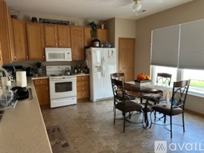 A kitchen with a table and chairs by a window.