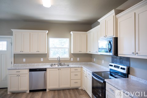A kitchen with white cabinets and a black stove top oven.