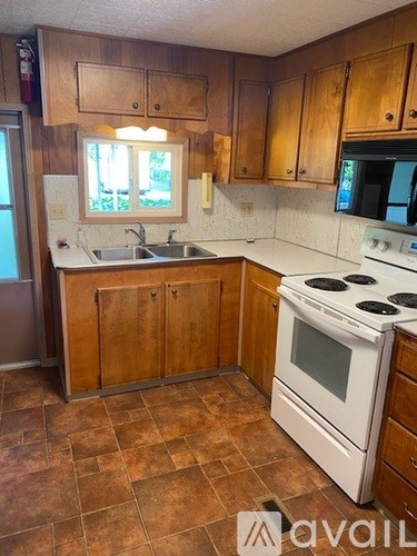 A kitchen with brown cabinets and a white stove.