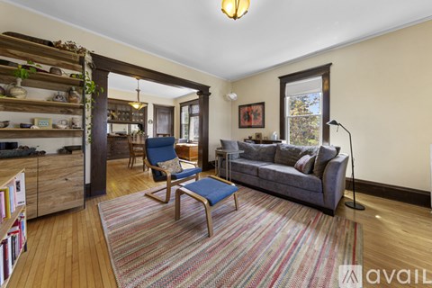 A living room with a blue chair and a grey couch.
