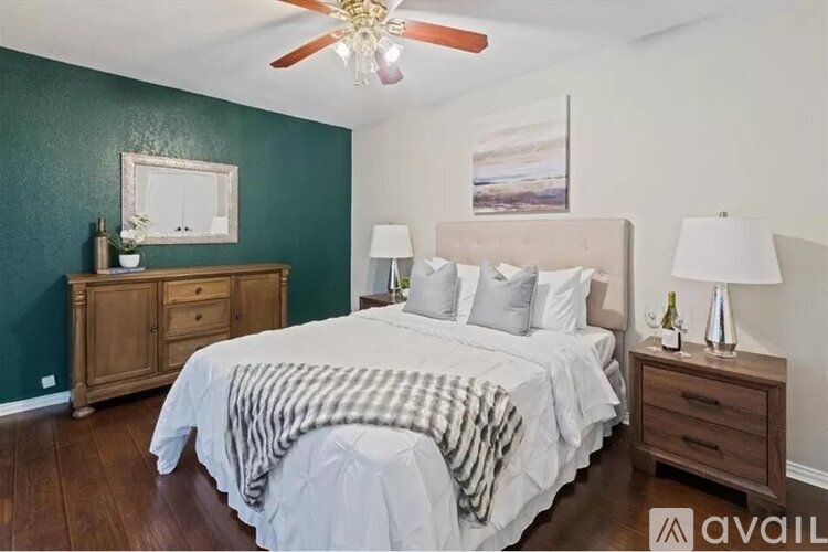 A bedroom with a bed, nightstands, and a ceiling fan.