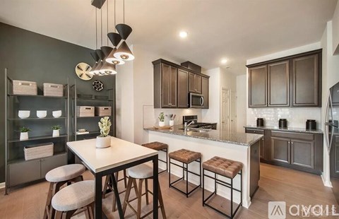 A modern kitchen with dark brown cabinets and a white island.