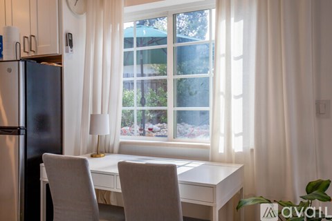 A kitchen with a table and chairs by a window.