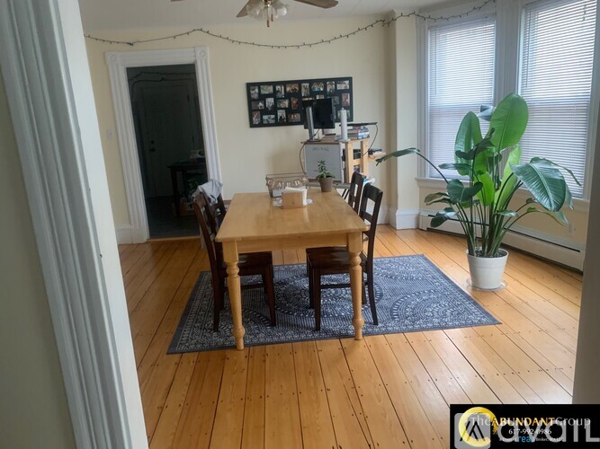 A dining room with a wooden table and chairs.