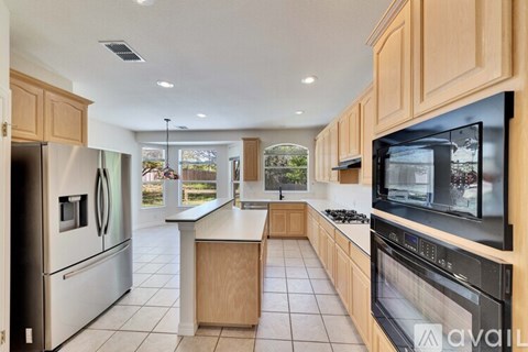 A kitchen with wooden cabinets and stainless steel appliances.