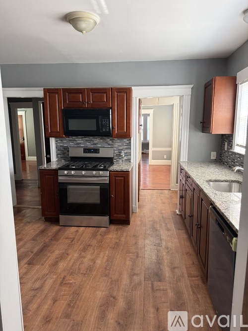A kitchen with wooden cabinets and a stone backsplash.