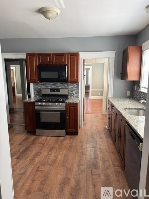A kitchen with wooden cabinets and a stone backsplash.
