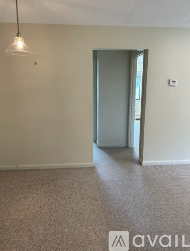 A room with a carpeted floor and a door leading to another room.