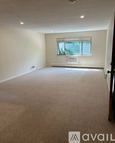 A carpeted room with a window and a sign on the window sill.