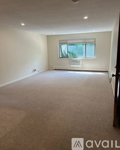 A carpeted room with a window and a sign on the window sill.