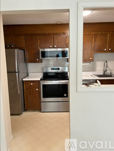 A kitchen with wooden cabinets and stainless steel appliances.