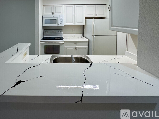 A kitchen with a white countertop that has a large crack running through it.