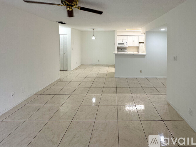 A spacious room with a ceiling fan and tiled flooring.