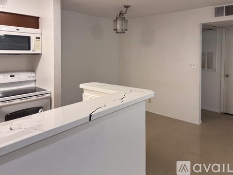 A kitchen with a white countertop and a microwave above it.