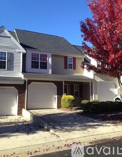 A house with a red tree in front.