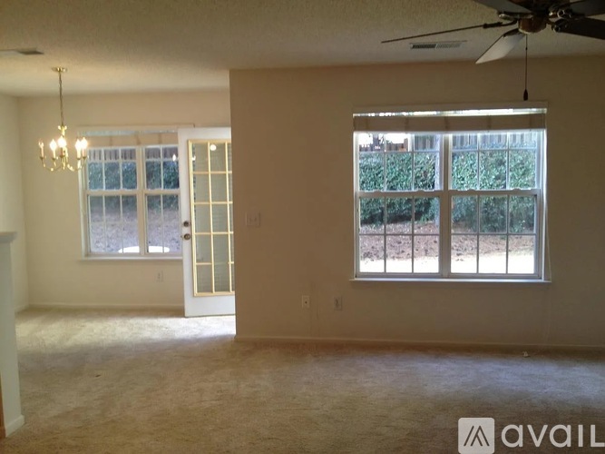 A room with a ceiling fan and a window with blinds.