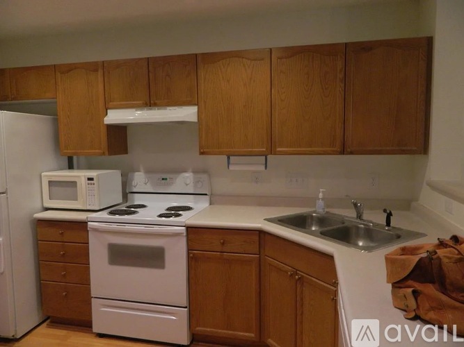 A kitchen with wooden cabinets and white appliances.