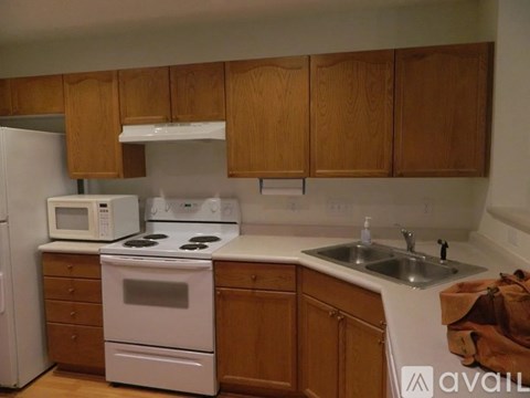 A kitchen with wooden cabinets and white appliances.