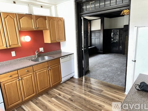 A kitchen with wooden cabinets and a red backsplash.
