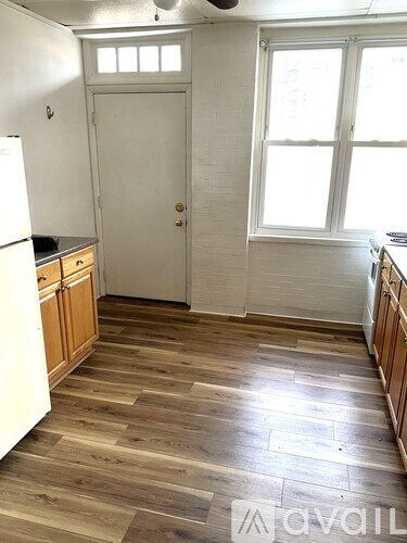 A kitchen with wooden floors and white appliances.