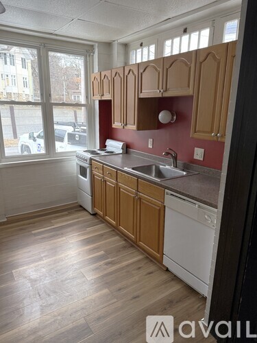 A kitchen with wooden cabinets and a white dishwasher.