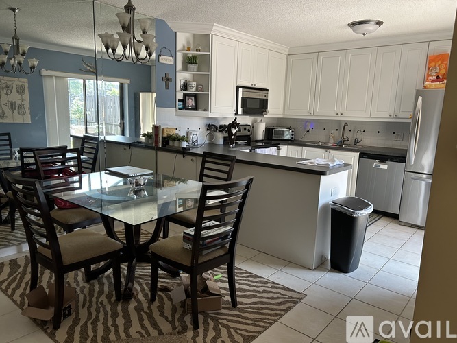 A kitchen with a table and chairs in the foreground.