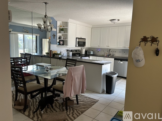A kitchen with a table and chairs in the foreground.