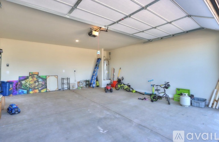 A spacious garage with a ladder, bicycles, and a mural on the wall.